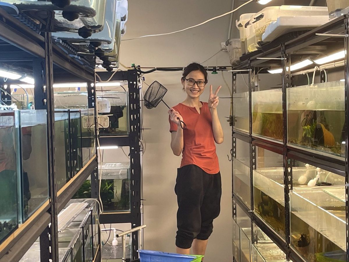A Micro Aquatic Shop team member beside the aquariums